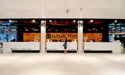 Hotelrezeption mit Hamilton-Logo und modernem Empfangsbereich
