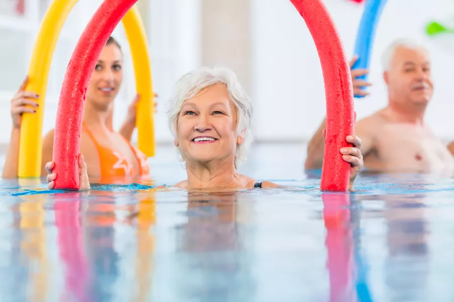 Menschen, die im Schwimmbad Gymnastik machen