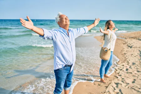 Hispanisches Paar atmet am Strand im Mittelalter während einer Atemtherapie