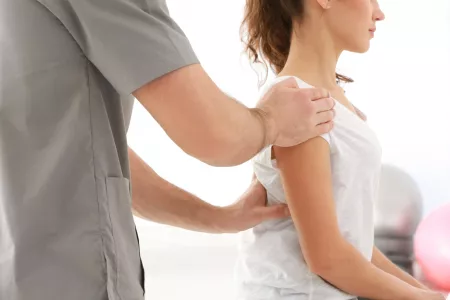 Physiotherapeutin arbeitet mit einem Patienten während einer craniosakralen Therapie-Behandlung.