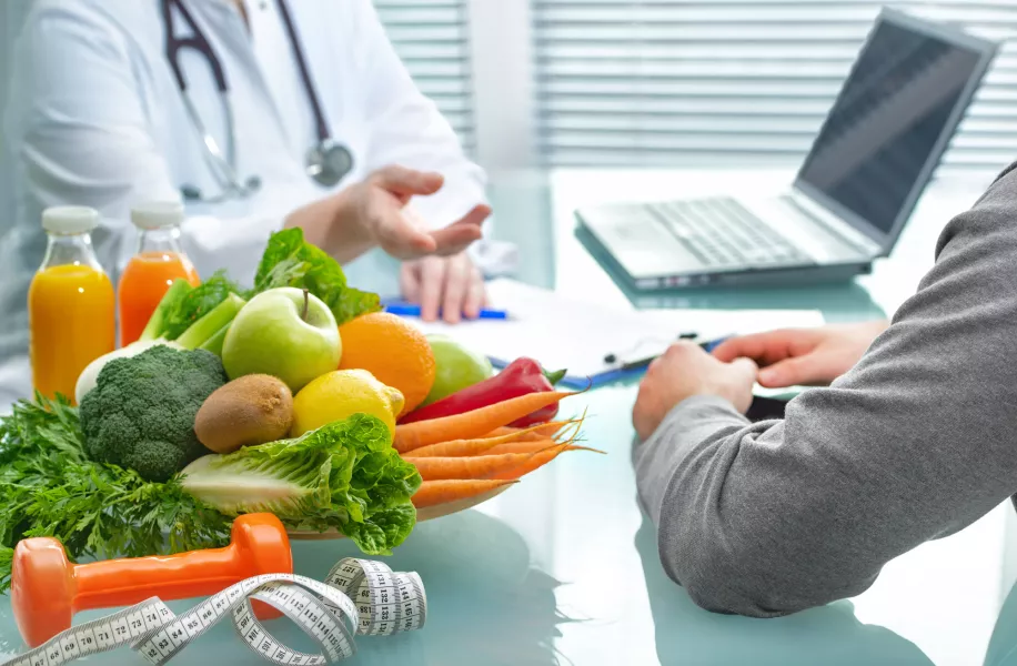 Ernährungsberater berät den Patienten über gesunde Ernährung mit Gemüse und Obst bei einer Kuraufenthalt.