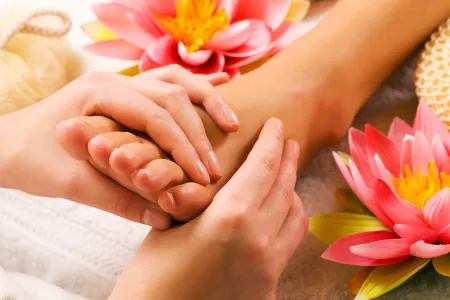 Frauen genießen Fuß-Reflexzonen-Massage im Wellnessbereich bei Kuraufenthalt