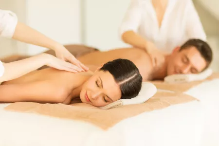 Paar erhält Rückenmassage im Wellnessbereich