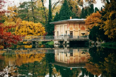 ein weißes und braunes Gebäude neben dem See