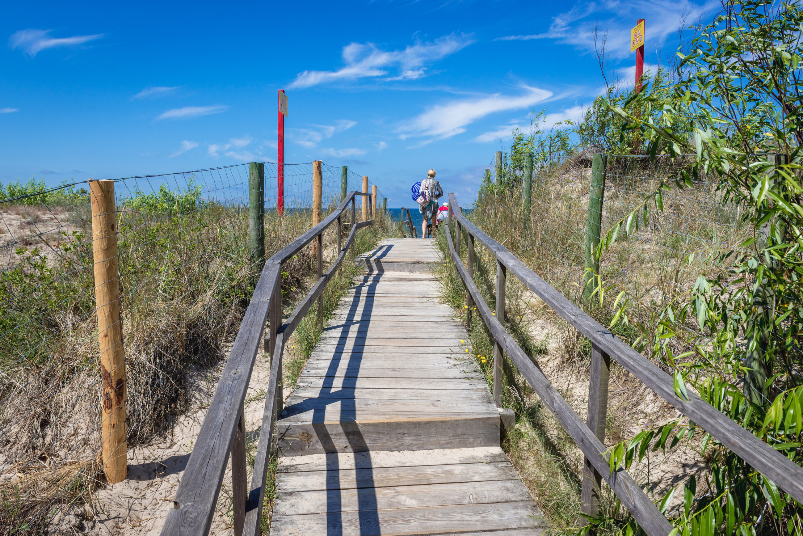 Holzweg auf einer Ostseedüne führt zu einem Strand im Dorf Miedzywodzie, Polen